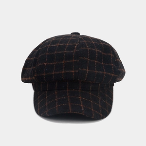 Detail of vintage wool tweed texture on a black and brown plaid newsboy cap