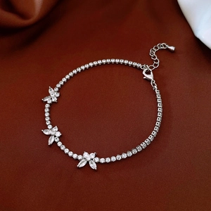 Detail of silver butterfly bracelet with cubic zirconia on deep red silk fabric