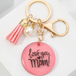 Porte-clés maman en résine rose avec pompon doré, perle et inscription gravée