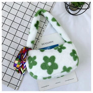 Close-up of white plush handbag with green floral pattern and decorative silk scarf