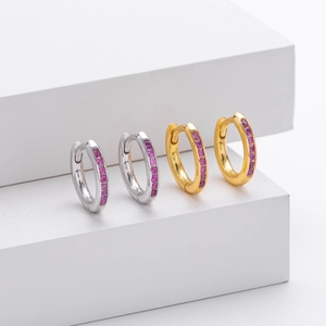 Detail of silver and gold hoop earrings featuring pavé set rose red zircon crystals