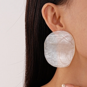 Close-up of model wearing pearlescent white resin irregular round earrings for women