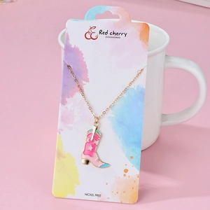 Primo piano di una collana con ciondolo a stivale in metallo rosa con motivi a stella