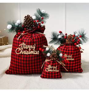 Detailed set of three red plaid Christmas gift bags with pine cones and berries