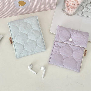 Detail view of colorful quilted mini storage pouches for sanitary pads and lipstick