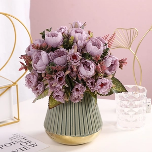 Detailed close-up of purple silk peony petals with a green gold-rimmed ceramic vase