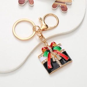 Detailed macro view of a golden Christmas gift box keychain with rhinestones and enamel craft
