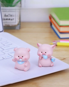 Macro detail of cute pink resin pig ornaments with blue pacifier and water bottle accessories