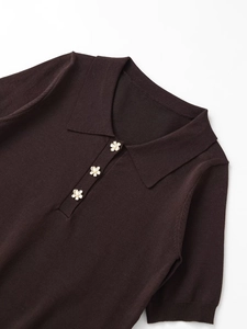 Detail of dark brown polo collar top with elegant flower-shaped pearl buttons