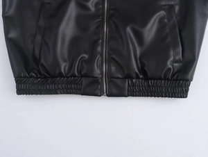 Detail of faux leather jacket with ribbed elastic hem and metal zipper closure