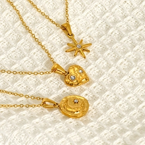 Detailed view of three-piece gold-plated star, heart, and moon pendant necklace set