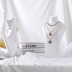 Three-layer gold necklace with world map pendant on minimalist resin mannequin display