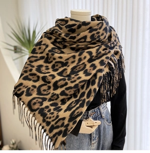 Detailed view of leopard print scarf featuring soft cashmere texture and elegant fringe
