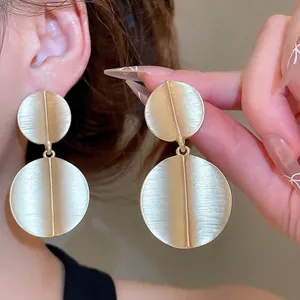 Golden brushed metal double disc drop earrings with minimalist round pendant design