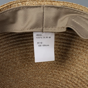 Detail of hand-woven natural straw equestrian hat with adjustable inner band and wash label
