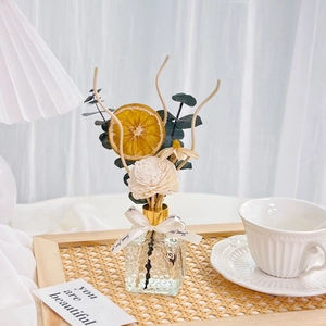 Preserved flower reed diffuser with dried orange slices on a woven tray decor