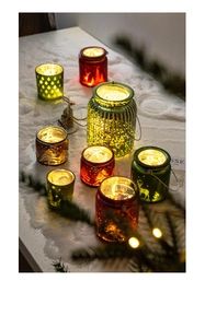 Détail de photophores de Noël en verre avec motifs rennes et lumières LED chaudes