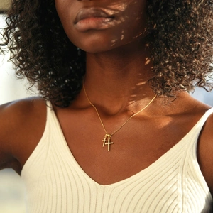 Close-up of dual gold cross pendants with sparkling cubic zirconia on a delicate chain