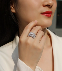 Nahaufnahme eines breiten Moissanit-Ringes in Silber am Finger eines Models im Freien