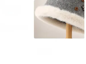 Dettaglio cappello a secchiello in lana grigia con bordo in peluche e bottone in legno