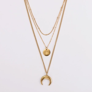 Detail of layered gold necklaces featuring starburst and crescent moon pendants