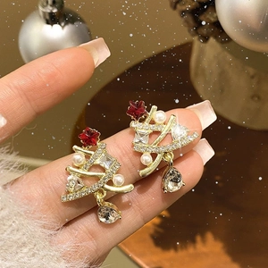 Christmas tree earrings with pearls and red star charm in festive holiday setting