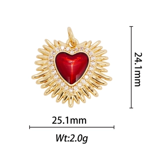 Macro shot of 18k gold plated heart wing pendant with red enamel and white zircon stones