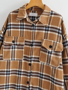 Vue détaillée du manteau en laine à carreaux marron et bleu ciel avec deux poches de poitrine