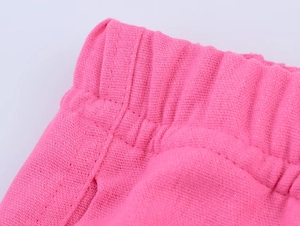 Détail de la texture en coton rose tricoté et taille élastique du pantalon large
