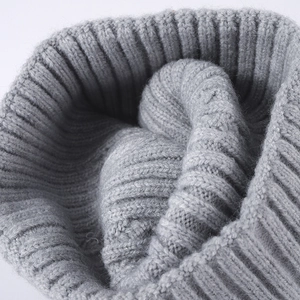 Chic grey cable knit beanie with warm ear protection and thick winter fleece texture
