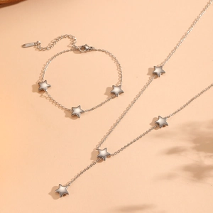Detailed view of silver star pendant necklace and bracelet set in polished stainless steel
