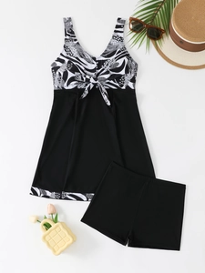 Flat lay detail of printed skirt tankini swim dress with bow accent and matching shorts