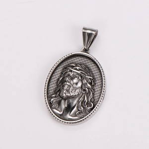 Macro shot of silver oval pendant with Jesus portrait relief and thorn crown detail