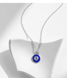 Macro detail of S925 silver necklace with blue enamel evil eye and sparkling crystal