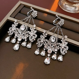 Detailed close-up of silver tassel clip-on earrings with rhinestones and teardrop charms