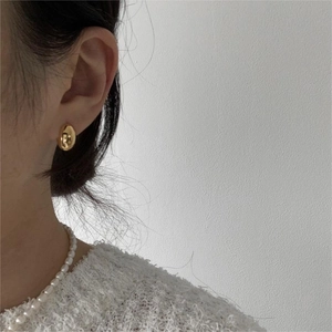 Minimalist oval gold earrings and pearl necklace set on model with a clean aesthetic