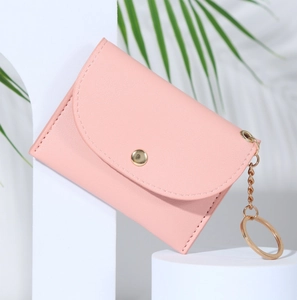 Détail du portefeuille enveloppe en cuir rose avec bouton-pression doré et chaîne