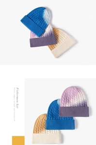 Close-up of thick cable knit texture and gradient tie-dye effect on a ribbed beanie
