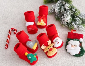 Close-up of red festive baby Christmas socks with 3D Santa and reindeer decorations