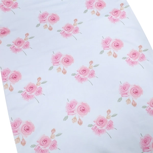 Close-up detail of soft white fabric featuring elegant pink rose floral print patterns
