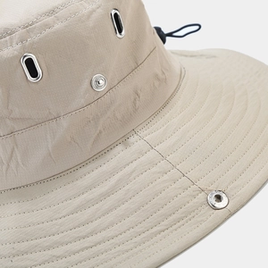 Dettaglio cappello da trekking con fori di ventilazione in metallo e cordino elastico