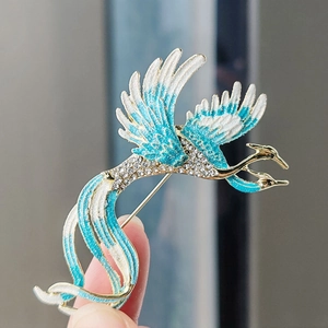 Detail of colorful enamel phoenix brooch with blue gradients and sparkling crystals