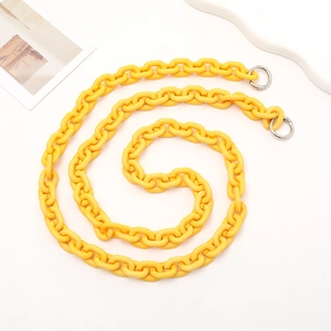 Macro detail of lemon yellow acrylic bag strap chain with silver metal spring rings