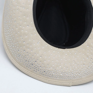 Close-up of sparkling white rhinestones on a beige faux suede Western cowboy hat