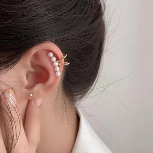 Elegant gold ear cuff with five pearls in an arc shown on ear for women