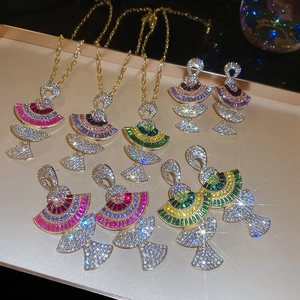 Detail of luxurious gold plated fan shaped necklaces and earrings set with colorful crystals