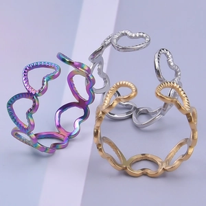 Three open heart-shaped rings in gold, silver, and rainbow stainless steel finishes