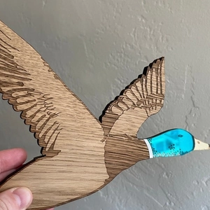 Détail de décoration murale canard en bois avec tête en acrylique bleu sarcelle