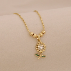 Detailed macro view of 18K gold plated sunflower pendant with zircon and beaded chain