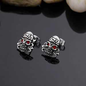 Dettaglio macro di orecchini a teschio punk vintage con occhi di zircone rosso su specchio